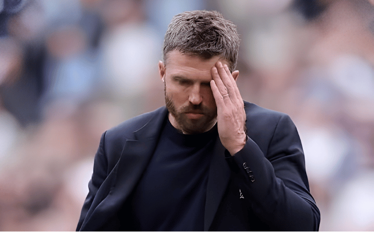 Manchester United manager Michael Carrick holding his head in frustration during a match.