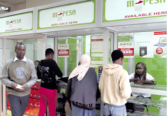 Customers conducting transactions at an M-PESA agent counter as Safaricom secures financial operations against cyber attack threats.