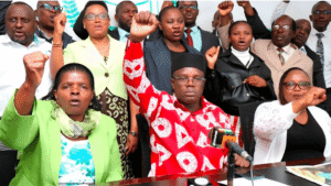 UASU union officials and public university lecturers raise their fists during a press conference to reject CS Ogamba’s return-to-work order.