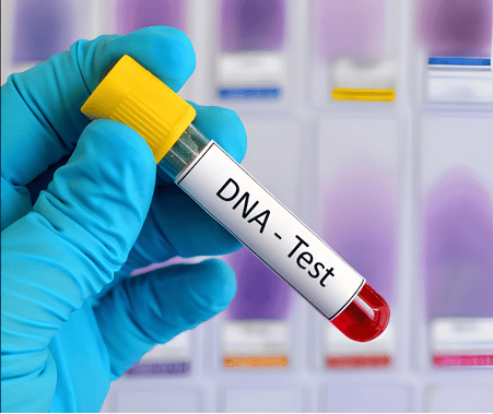 A medical professional holding a blood sample vial labeled DNA tests in a laboratory setting.