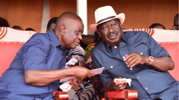 Dr. Oburu Odinga conferring closely with the late ODM leader Raila Odinga during a public event.