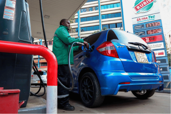 A station attendant dispensing fuel into a blue car amid the new EPRA fuel prices announcement.